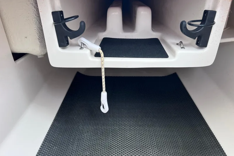 Slide: The Image of 2019 Robalo R247 Dual Console interior storage compartment with black non-slip mat. - 55