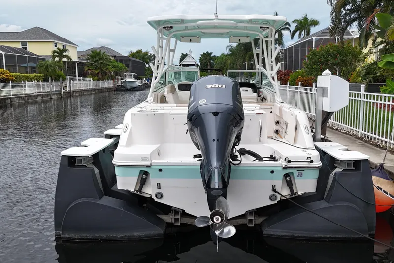 Slide: The Image of 2019 Robalo R247 Dual Console boat docked in a canal, rear view. - 6