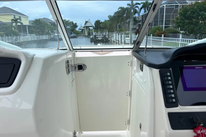 Slide: The Image of 2019 Robalo R247 Dual Console boat interior with dashboard and waterway view. - 61