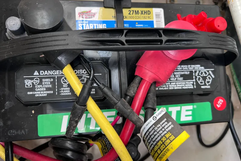 Slide: The Image of Marine battery with cables in a 2019 Robalo R247 Dual Console boat. - 65