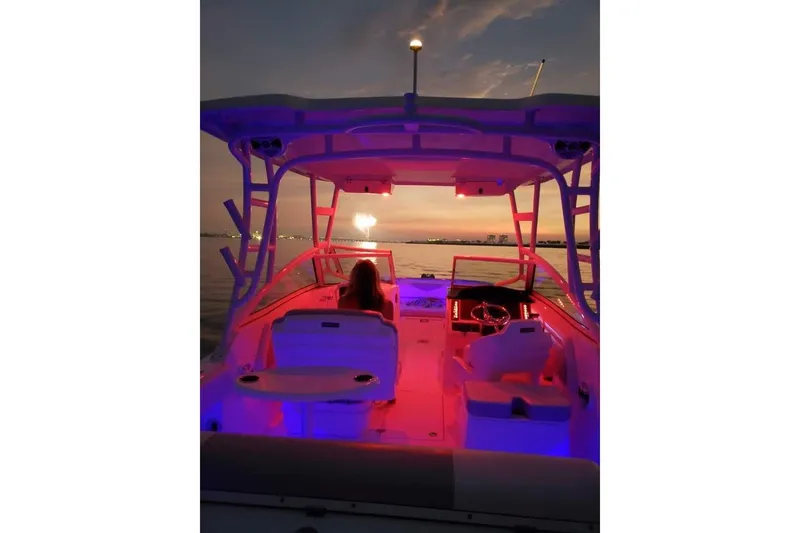 Slide: The Image of 2019 Robalo R247 Dual Console boat with vibrant interior lighting at sunset. - 67