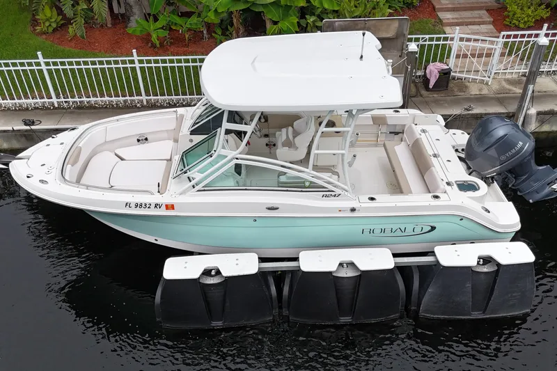 Slide: The Image of 2019 Robalo R247 Dual Console boat docked, featuring sleek design and Yamaha engine. - 8