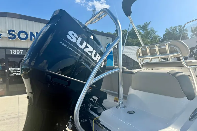 Slide: The Image of 2026 Key West 189 FS boat with Suzuki outboard motor, parked outside a dealership. - 26