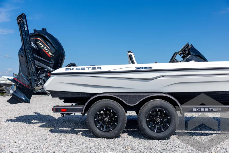 Slide: The Image of 2026 Skeeter ZXE21 boat on trailer, featuring Yamaha engine, parked on gravel under clear blue sky. - 13