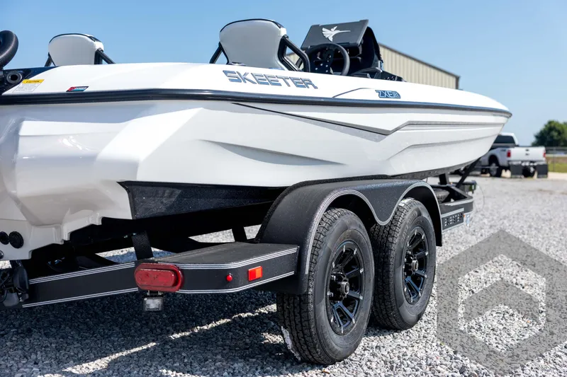Slide: The Image of 2026 Skeeter ZXE21 boat on trailer, parked on gravel, showcasing sleek design. - 16
