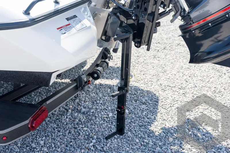 Slide: The Image of Skeeter ZXE21 2026 boat trailer hitch and motor detail on gravel surface. - 24