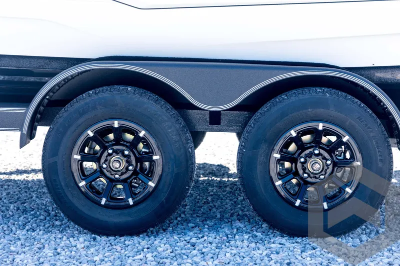 Slide: The Image of 2026 Skeeter ZXE21 trailer wheels on gravel surface, featuring sleek black rims. - 30