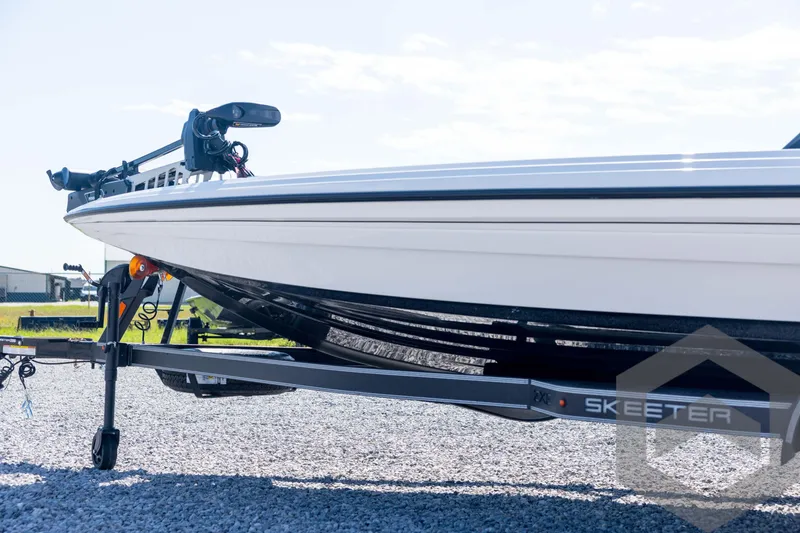 Slide: The Image of 2026 Skeeter ZXE21 boat on trailer, parked on gravel under clear sky. - 32