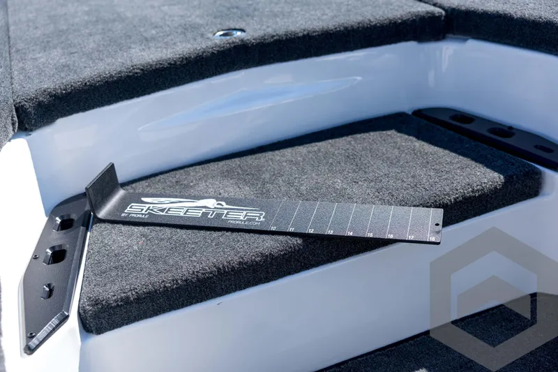 Slide: The Image of 2026 Skeeter ZXE21 boat deck with measuring tool on carpeted surface. - 53