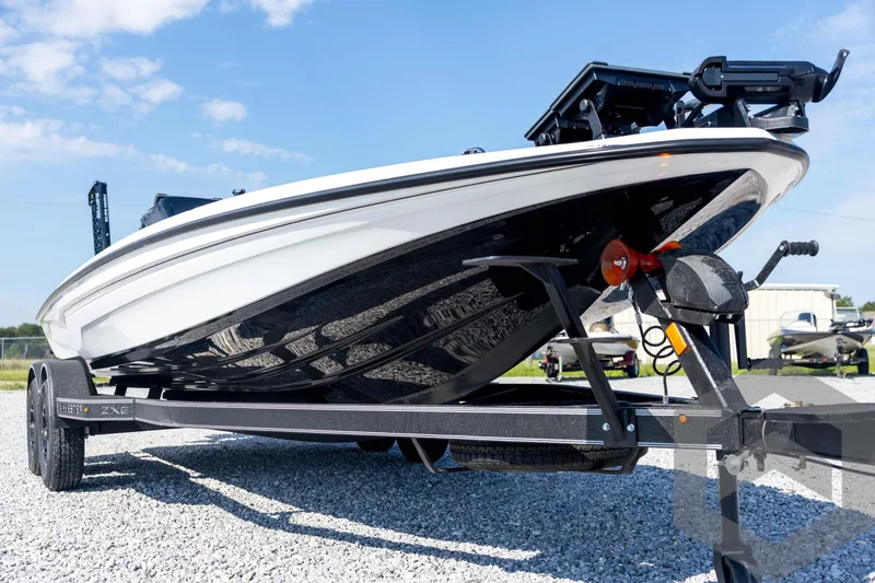 Slide: The Image of 2026 Skeeter ZXE21 boat on trailer, parked on gravel under blue sky. - 9