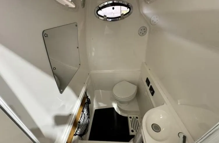 Slide: The Image of 2009 MasterCraft CSX 265 SS boat interior with compact bathroom and porthole window. - 15
