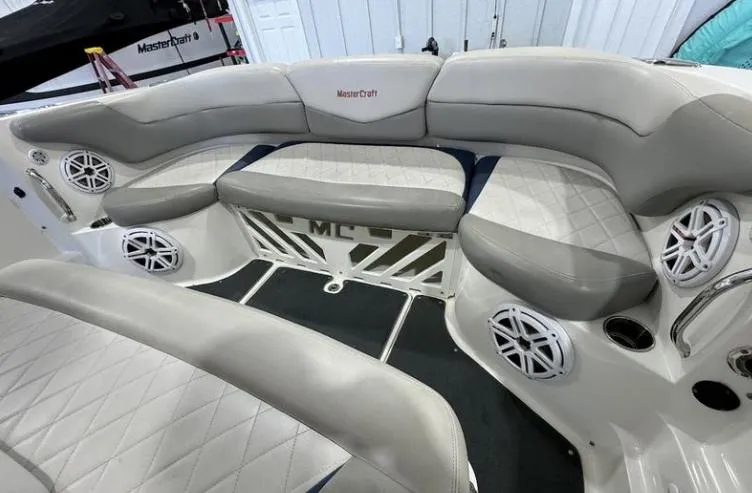 Slide: The Image of 2009 MasterCraft CSX 265 SS boat interior with cushioned seating and built-in speakers. - 17