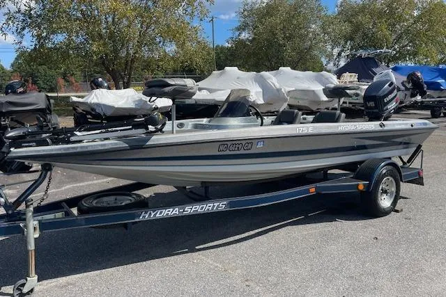 Slide: The Image of 1996 Hydra-Sports 175E boat on trailer, parked outdoors, with trees in the background. - 2