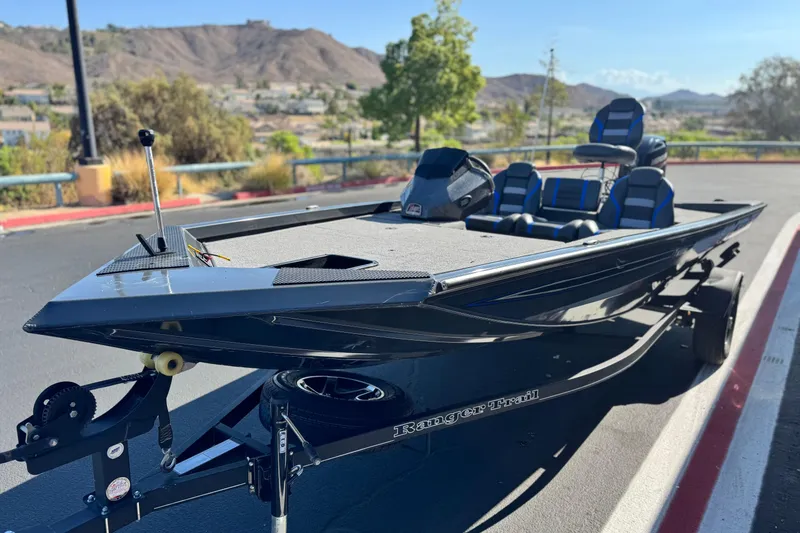 Slide: The Image of 2021 Ranger RT178 boat on trailer, parked outdoors with scenic mountain backdrop. - 3