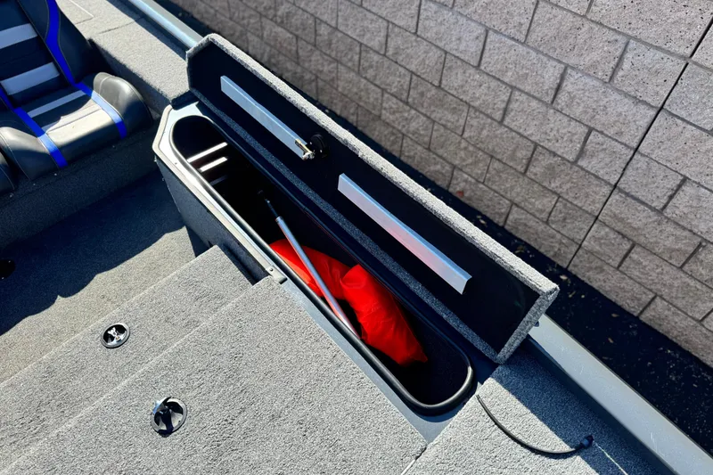Slide: The Image of 2021 Ranger RT178 boat storage compartment with red life jacket and rod. - 9