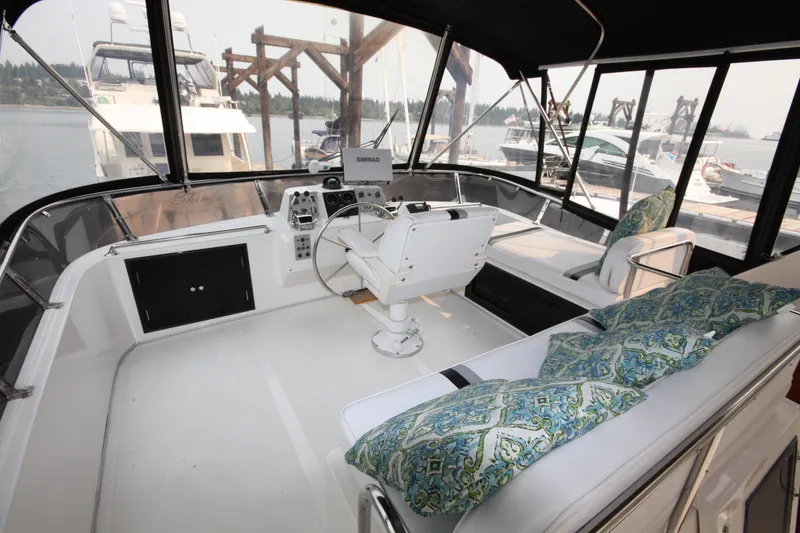 Slide: The Image of 1989 Ocean Alexander 420 Cockpit Motor Yacht interior with helm, seating, and decorative cushions. - 10
