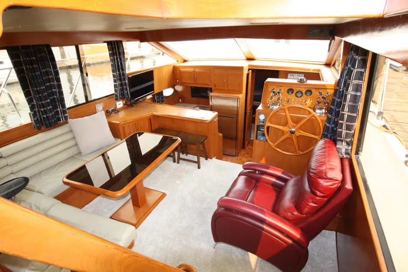 Slide: The Image of Luxurious interior of 1989 Ocean Alexander 420 Cockpit Motor Yacht with leather seating and wooden helm. - 13
