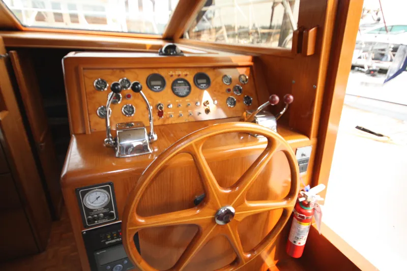 Slide: The Image of 1989 Ocean Alexander 420 Cockpit Motor Yacht helm with wooden steering wheel and control panel. - 14