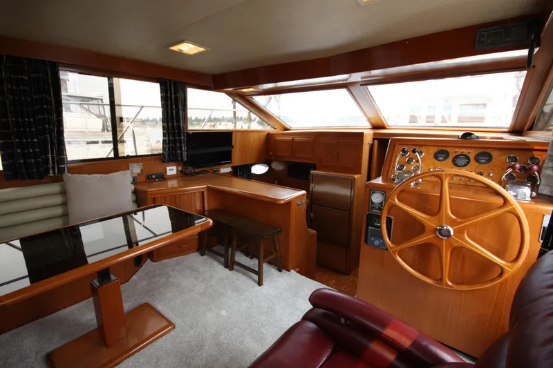 Slide: The Image of 1989 Ocean Alexander 420 Cockpit Motor Yacht interior with helm, seating, and dining area. - 18