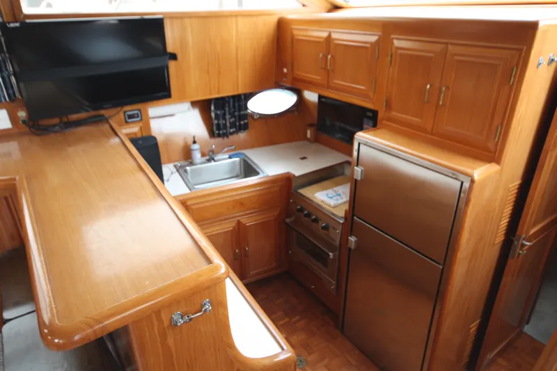 Slide: The Image of 1989 Ocean Alexander 420 Cockpit Motor Yacht kitchen with wood cabinetry and modern appliances. - 22