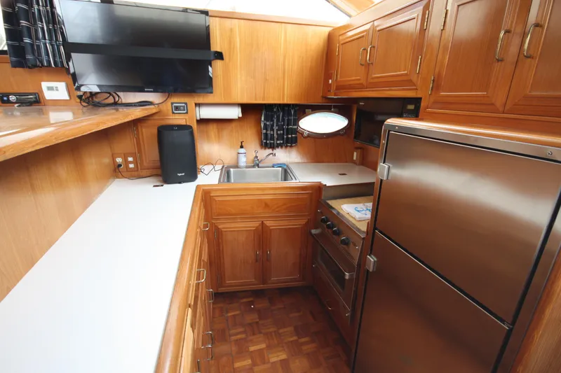 Slide: The Image of 1989 Ocean Alexander 420 Cockpit Motor Yacht kitchen with wood cabinetry and modern appliances. - 23