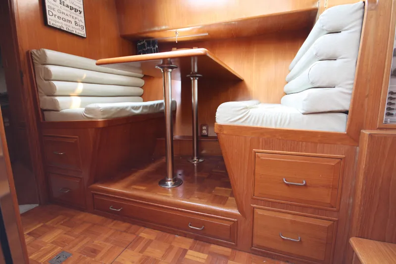Slide: The Image of 1989 Ocean Alexander 420 Cockpit Motor Yacht interior with cushioned seating and wooden cabinetry. - 25