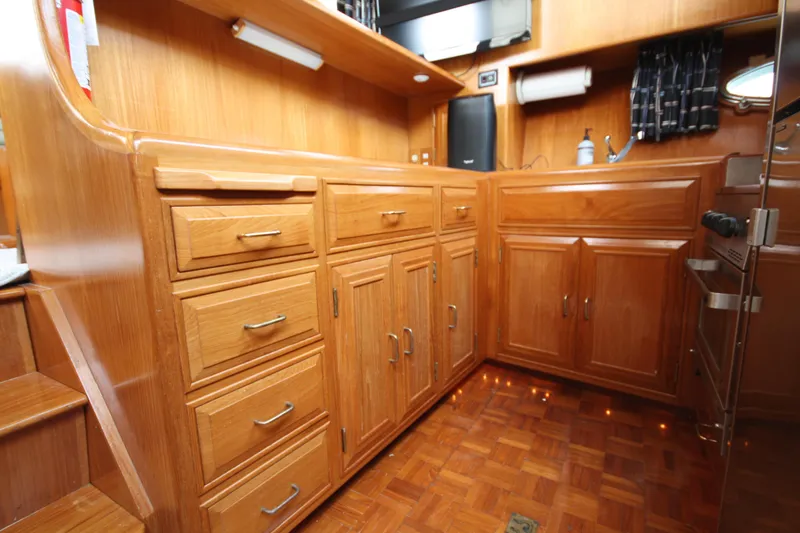 Slide: The Image of 1989 Ocean Alexander 420 Cockpit Motor Yacht interior with wooden cabinetry and parquet flooring. - 26