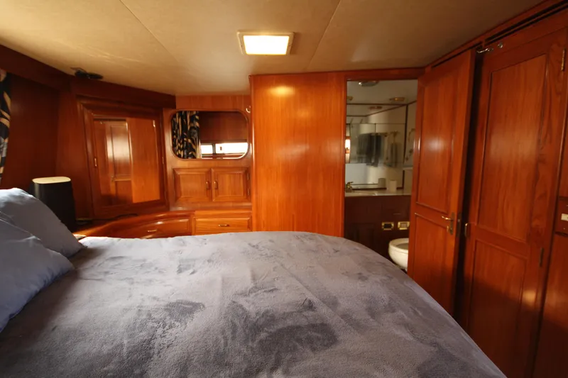 Slide: The Image of Luxurious 1989 Ocean Alexander 420 yacht bedroom with wood paneling and ensuite bathroom. - 32