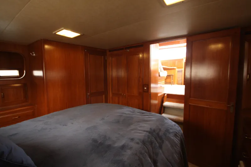 Slide: The Image of 1989 Ocean Alexander 420 Cockpit Motor Yacht cabin with wooden interior and cozy bedding. - 34