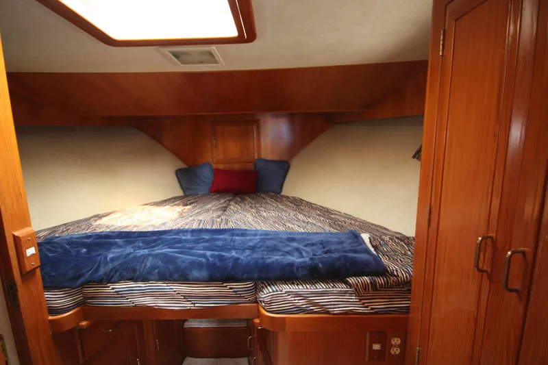 Slide: The Image of 1989 Ocean Alexander 420 Cockpit Motor Yacht bedroom with cozy bedding and wooden cabinetry. - 42