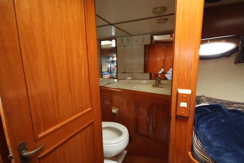Slide: The Image of 1989 Ocean Alexander 420 Cockpit Motor Yacht interior with wooden cabinetry and compact bathroom. - 43