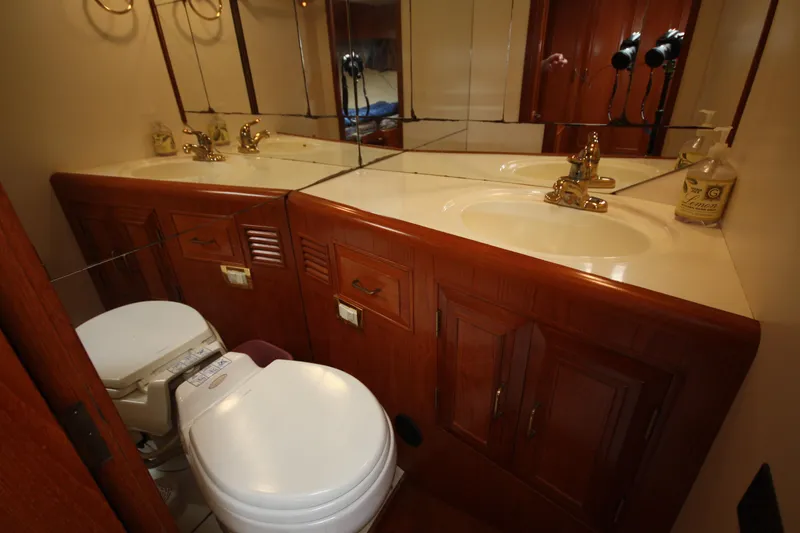 Slide: The Image of Luxurious bathroom in 1989 Ocean Alexander 420 Cockpit Motor Yacht with wood cabinetry and mirrored vanity. - 44