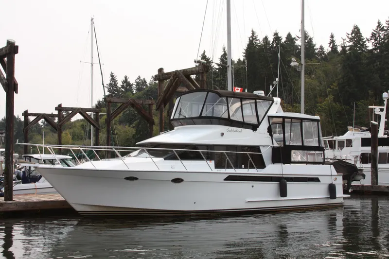 Slide: The Image of 1989 Ocean Alexander 420 Cockpit Motor Yacht docked in a serene marina setting. - 2