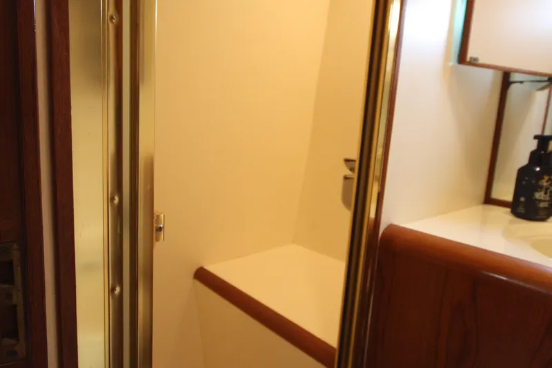 Slide: The Image of 1989 Ocean Alexander 420 Cockpit Motor Yacht bathroom interior with wooden accents and sink. - 38