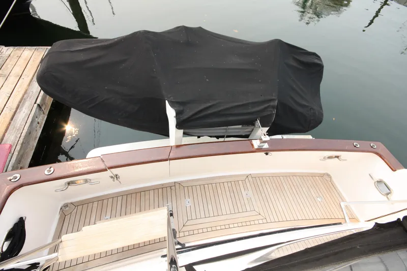 Slide: The Image of 1989 Ocean Alexander 420 Cockpit Motor Yacht with covered dinghy, docked on calm water. - 46