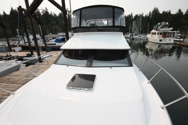Slide: The Image of 1989 Ocean Alexander 420 Cockpit Motor Yacht docked at marina, surrounded by trees and boats. - 47