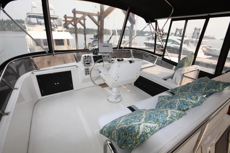 Slide: The Image of 1989 Ocean Alexander 420 Cockpit Motor Yacht interior with helm, seating, and decorative cushions. - 7