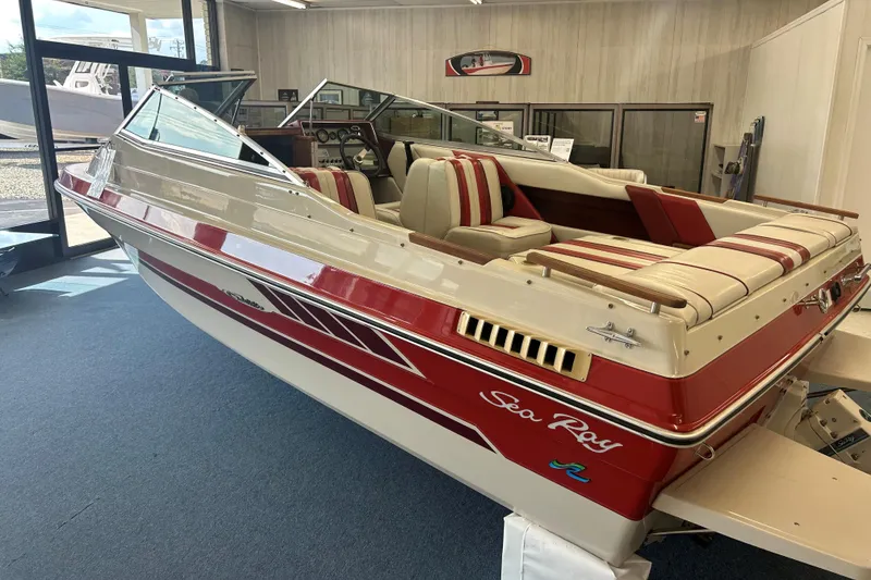 Slide: The Image of 1987 Sea Ray 19 Seville Cuddy Cabin boat with red and white interior on display. - 1
