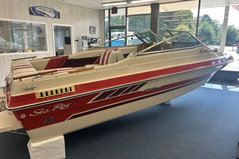 Slide: The Image of 1987 Sea Ray 19 Seville Cuddy Cabin boat displayed indoors, featuring red and beige design. - 3