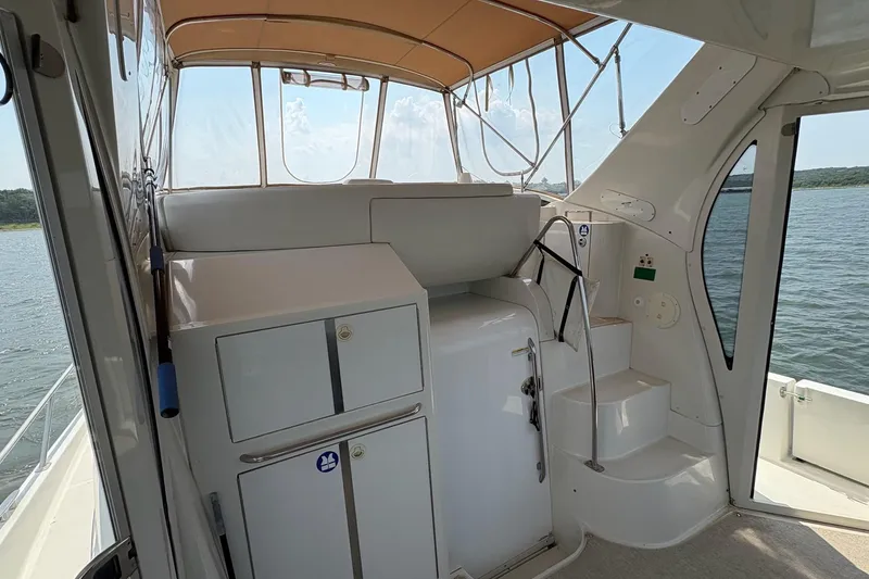 Slide: The Image of Interior of 2003 Carver 396 Motor Yacht with seating, helm, and kitchenette on a sunny day. - 21
