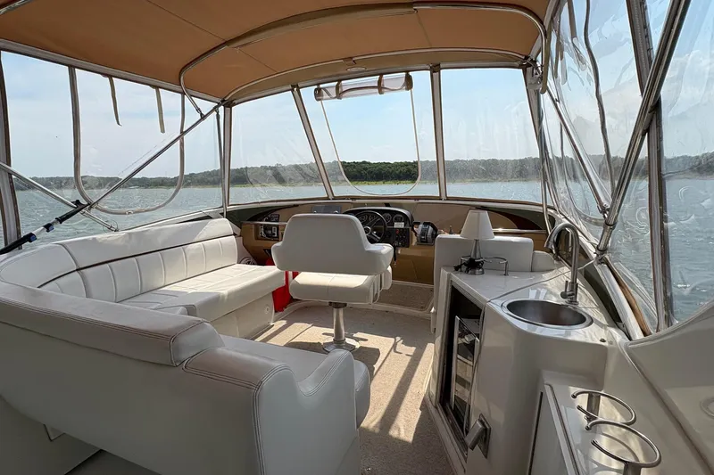 Slide: The Image of 2003 Carver 396 Motor Yacht helm with steering wheel, gauges, and lake view. - 22