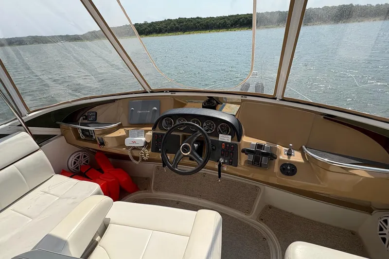Slide: The Image of 2003 Carver 396 Motor Yacht helm with panoramic water view and navigation controls. - 23