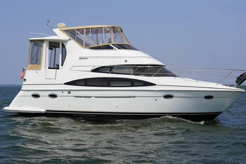 Slide: The Image of 2003 Carver 396 Motor Yacht cruising on open water under clear skies. - 3