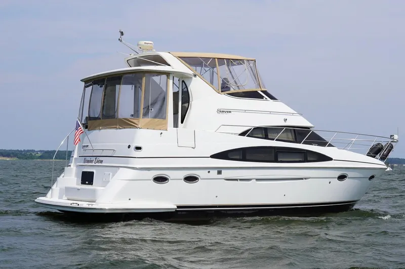 Slide: The Image of 2003 Carver 396 Motor Yacht cruising on open water, featuring elegant design and spacious deck. - 4