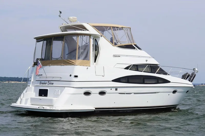 Slide: The Image of 2003 Carver 396 Motor Yacht cruising on open water, featuring elegant design and spacious deck. - 5