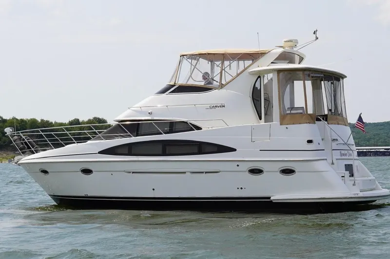 Slide: The Image of 2003 Carver 396 Motor Yacht cruising on a lake with scenic background. - 8
