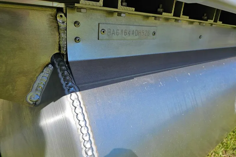 Slide: The Image of Close-up of 2026 Bentley Pontoons Legacy 223 Tritoon hull with visible welds and serial number. - 27