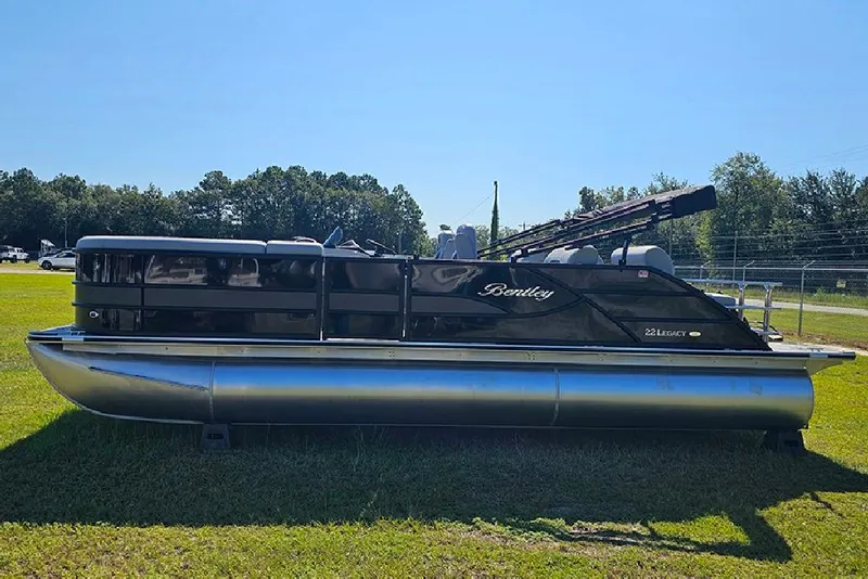 Slide: The Image of 2026 Bentley Pontoons Legacy 223 Quad Swing Back 3/4 Tritoon on grass, side view. - 6