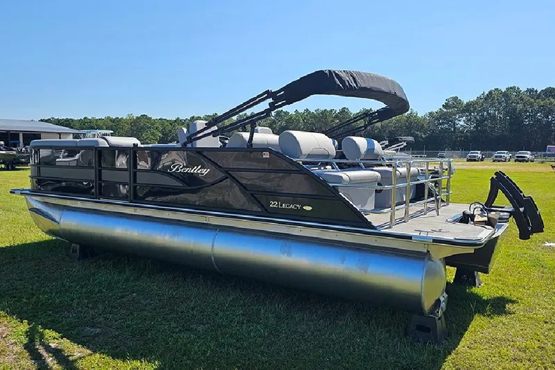 Slide: The Image of 2026 Bentley Pontoons Legacy 223 Quad Swing Back 3/4 Tritoon on grassy field. - 7