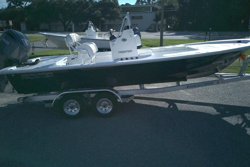 The Image of 2026 Frontier 2104 boat on trailer, parked outdoors in a sunny setting. - 1